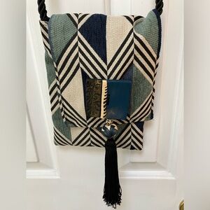 One of a kind fabric, clay, bead, tassel crossbody. Thick black braid-strap.